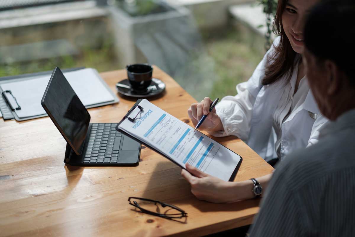 Insurance advisor reviewing employee benefits paperwork for a small business health insurance plan