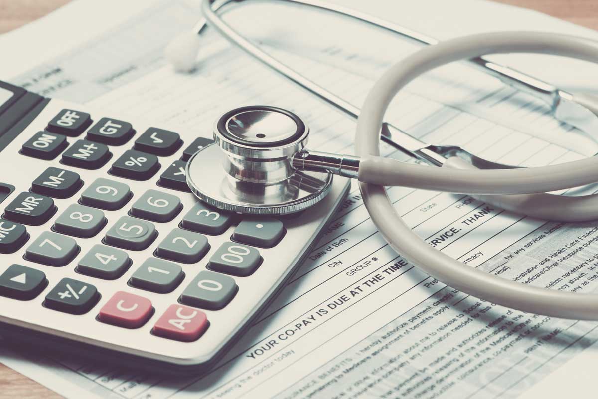 Health insurance cost planning with calculator and stethoscope for small business employee benefits